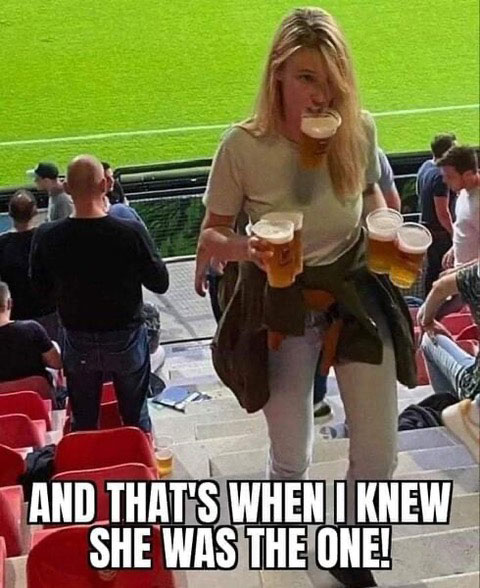Photo of a young woman carrying 5  beers up steep steps at baseball game.